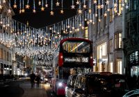 Cortinas de estrellas iluminadas sobre Oxford Street con un autobús rojo.