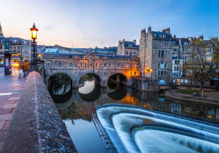 El Pulteney Bridge de Bath iluminado al amanecer sobre el río Avon.