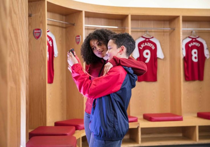 Una familia visita los vestuarios de los jugadores durante el tour del Emirates Stadium.