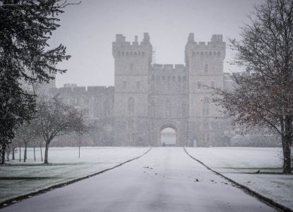 Vista invernal del Castillo de Windsor rodeado de nieve y niebla.