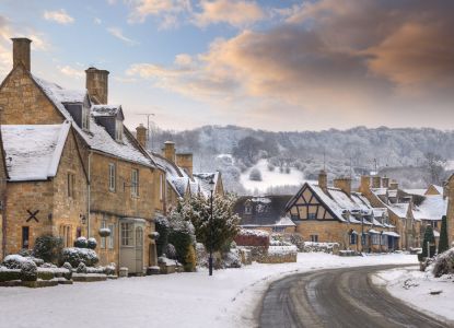 Casas de piedra de un pueblo de los Cotswolds nevado al atardecer.