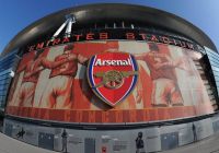 Vista exterior del Emirates Stadium con el escudo y las imágenes históricas del Arsenal.