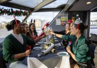 Pasajeros brindando y tirando de crackers navideños en la mesa del crucero.
