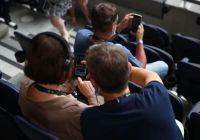 Visitantes con dispositivo multimedia en las gradas del Tottenham Hotspur Stadium