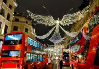 Autobuses rojos avanzando bajo los ángeles de luz de Regent Street.