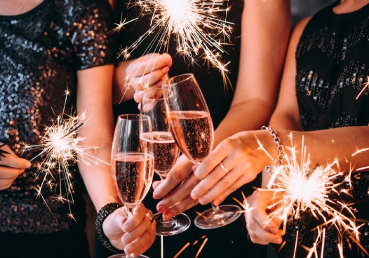 Brindis con copas de cava y bengalas en la fiesta de Nochevieja