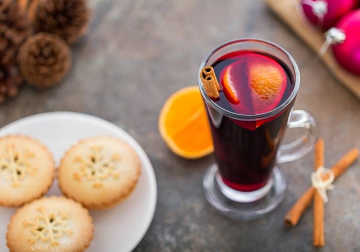 Mince pies y vino caliente especiado servidos con canela.