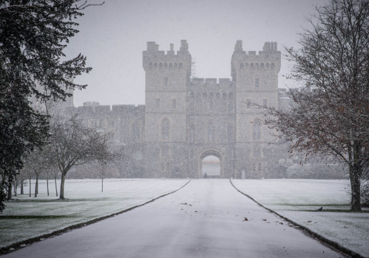Vista invernal del Castillo de Windsor rodeado de nieve y niebla.