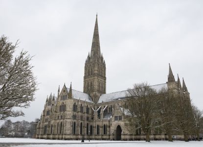 La catedral de Salisbury y su aguja gótica sobre el prado nevado.