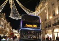 Autobús descubierto del tour de las luces navideñas circulando bajo la iluminación de Regent Street.