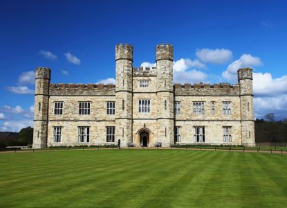 La fachada del Castillo de Leeds sobre el césped, bajo un cielo despejado.