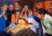 Una familia participa en una divertida escena interactiva de la atracción.