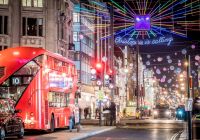 Un autobús rojo de dos pisos bajo las luces de «Christmas is calling» en Oxford Street.