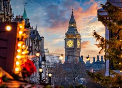 El Big Ben al atardecer enmarcado por luces navideñas.