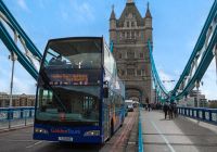 Autobús turístico cruzando el Tower Bridge entre sus dos torres góticas.