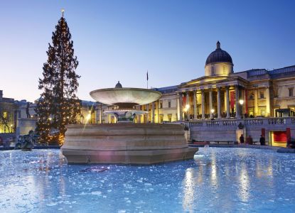 Trafalgar Square nevada con la National Gallery y el árbol de Navidad al fondo.