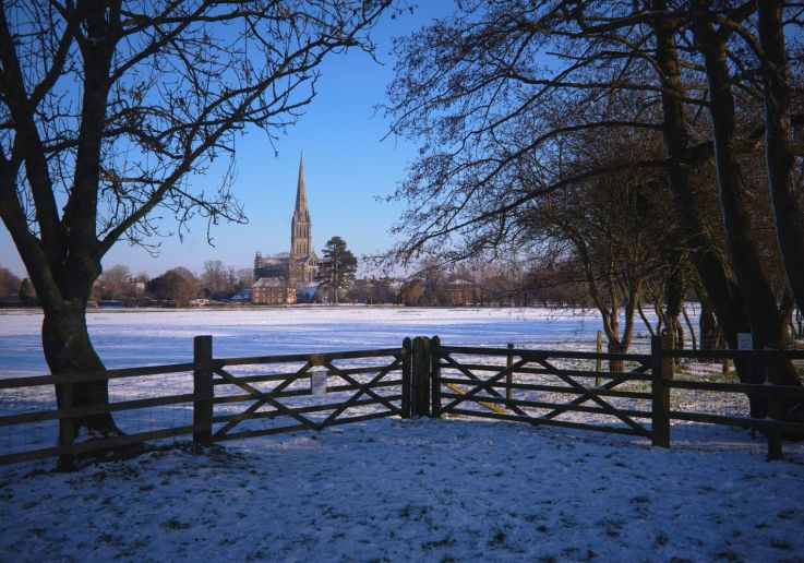 Vista de la Catedral de Salisbury a través del parque cubierto de nieve.