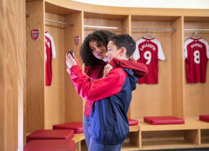 Una familia visita los vestuarios de los jugadores durante el tour del Emirates Stadium.