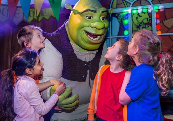 Niños conocen a Shrek en uno de los escenarios de la atracción.