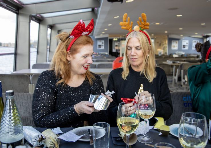 Dos pasajeras abriendo un regalo durante el almuerzo de Navidad a bordo.