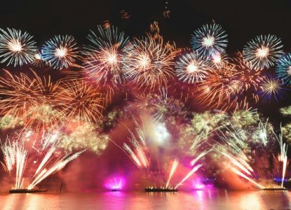 Fuegos artificiales de Fin de Año reflejados en el agua