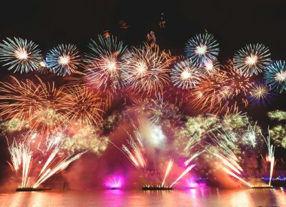 Fuegos artificiales lanzados desde barcazas en el agua