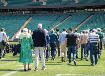 Un grupo de visitantes descubre el terreno de juego durante el tour del estadio.