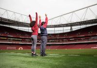 Dos visitantes descubren el terreno de juego durante el tour del estadio del Arsenal.