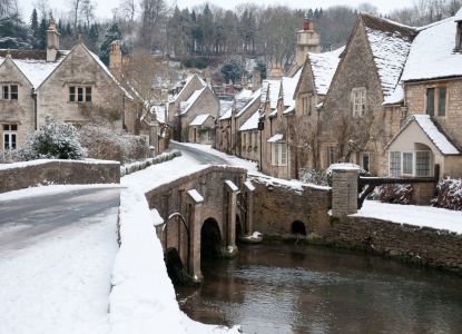El puente y las casas medievales de Castle Combe cubiertos de nieve.