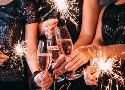 Brindis con copas de cava y bengalas en la fiesta de Nochevieja