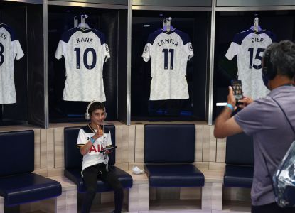 Visitantes fotografiando las camisetas colgadas en el vestuario de Wembley