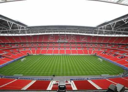 Gradas rojas y césped del estadio de Wembley vacío durante la visita guiada